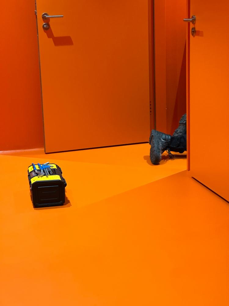 Minimalist Phone Photography: Capturing a Worker's Orange Toilet Scene