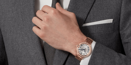 The Diamond Watch Game: Are You a Connoisseur ? - Man in gray suit wearing a Cartier Ballon Bleu Diamond watch in rose gold, close up.