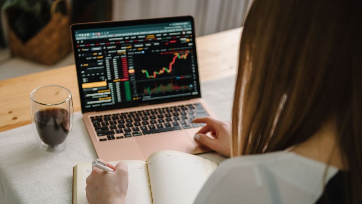 How Much Money Do I Need to Invest to Make $3000 a Month - Woman on laptop investing back view - Grand Goldman