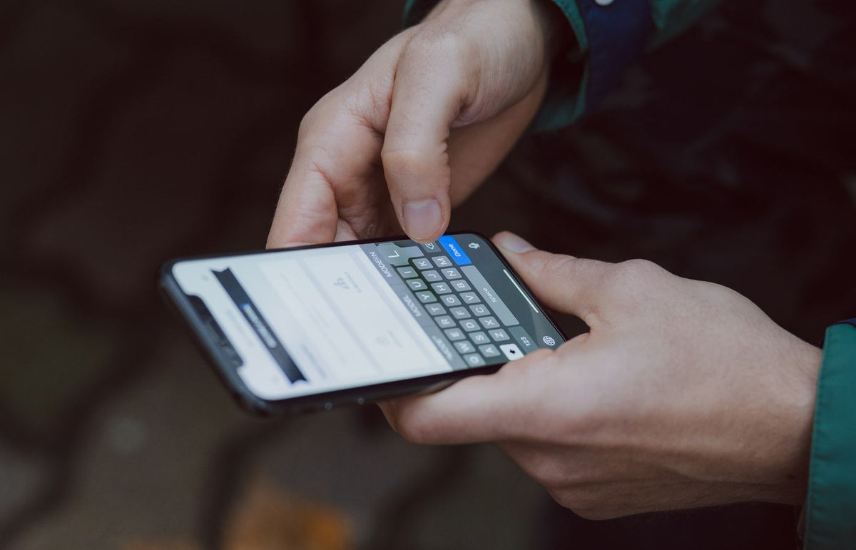 Close-up of person texting on a smartphone. Outdoor setting with wireless connectivity.