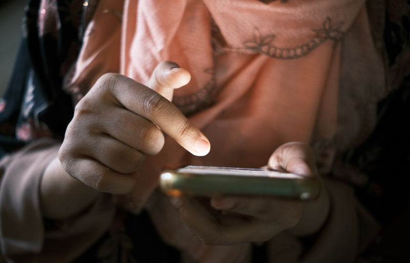 Close-up of hands using a smartphone indoors, highlighting touch technology.