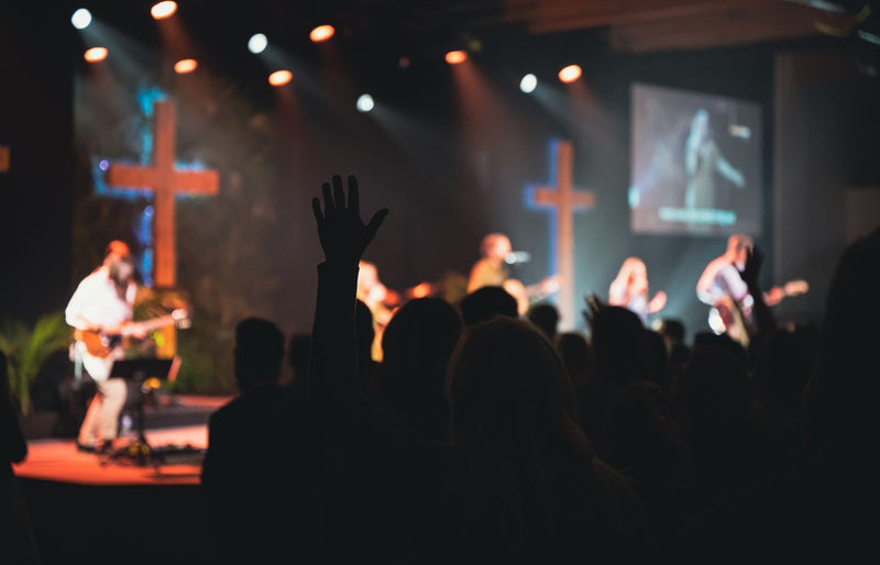 A vibrant church music band performing on stage with guitars and singers.