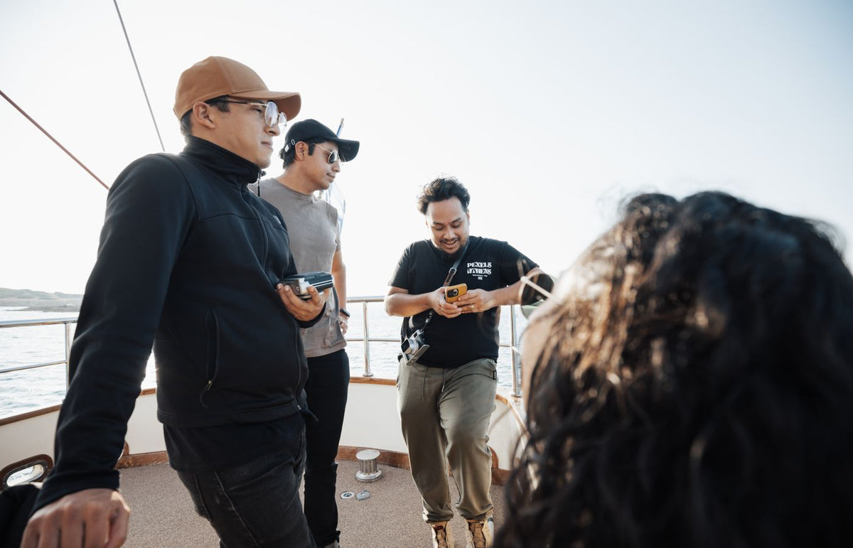 Group of friends relaxing on a yacht, enjoying sunny weather and socializing at sea.