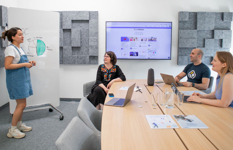 Team collaborating during a meeting with presentation and discussion in a modern office.