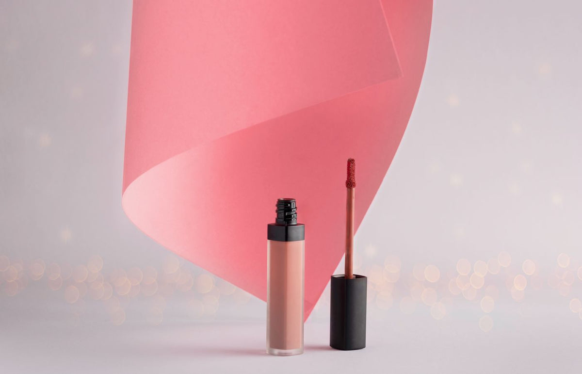 Stylish lipstick with a pink swirl backdrop, ideal for beauty and cosmetics themes.