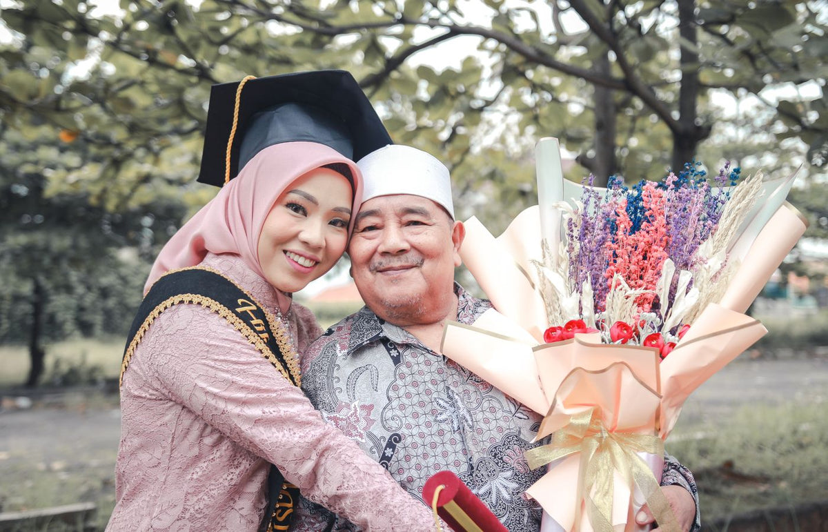 A joyful graduation moment with a father and daughter, showcasing family love and cultural celebration outdoors.