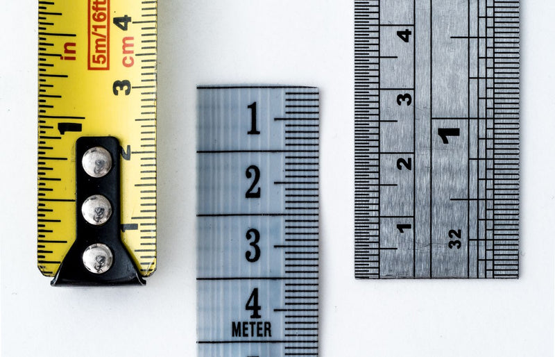 High-resolution image of a tape measure and rulers, showing precise millimeter, centimeter, and inch markings.
