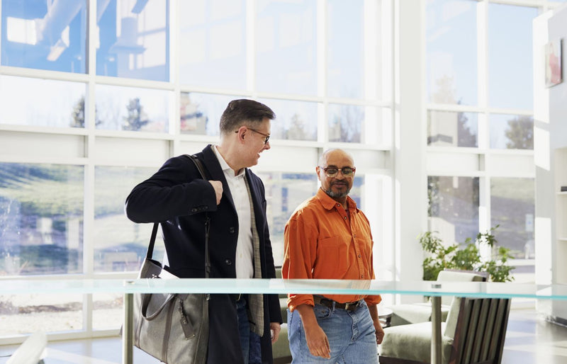 Two business professionals in a bright, modern office discussing their work.