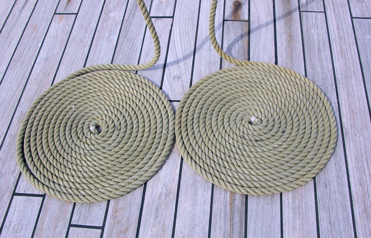 Two neatly coiled ropes on a wooden deck create a rustic nautical pattern.