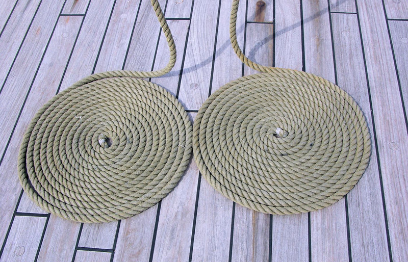 Two neatly coiled ropes on a wooden deck create a rustic nautical pattern.
