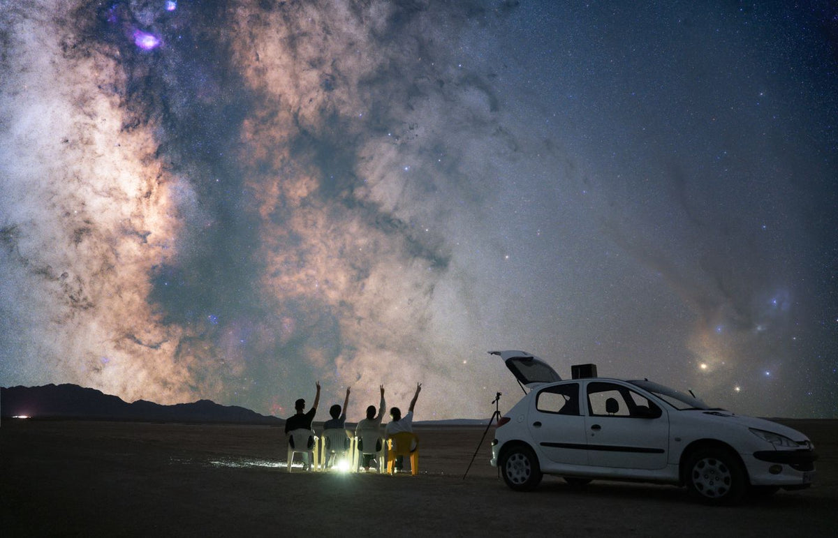 A group of stargazers observing the Milky Way in Semnan, Iran with a car and telescope.