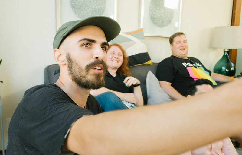 Casual gathering of friends laughing and enjoying indoors on a cozy sofa.