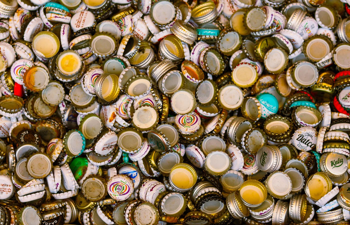 Close-up of multiple colorful bottle caps laid out for recycling and art projects.