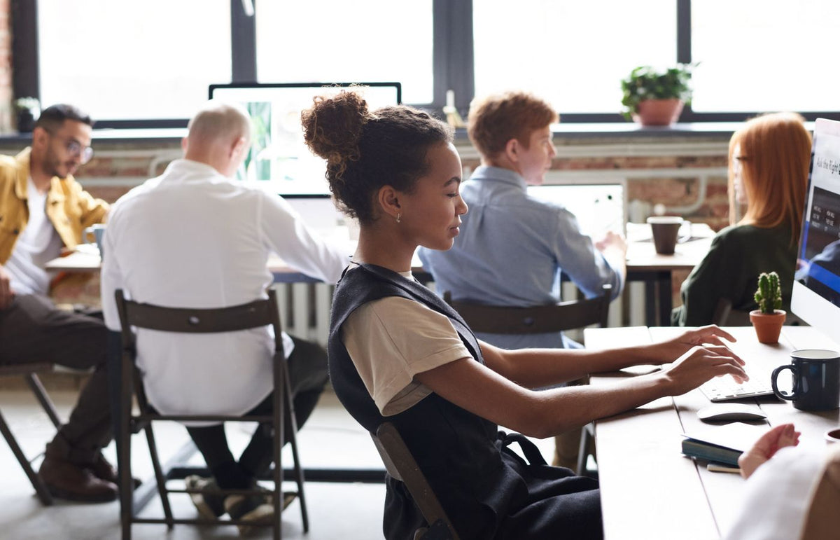 A diverse group of professionals working together in a modern office environment, focused on teamwork.