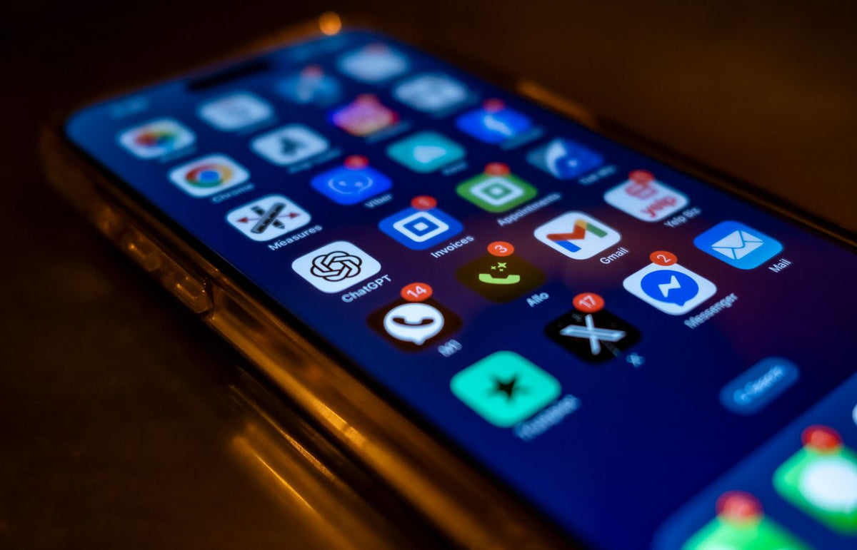 Smartphone screen showing various app icons with notification badges in low light.