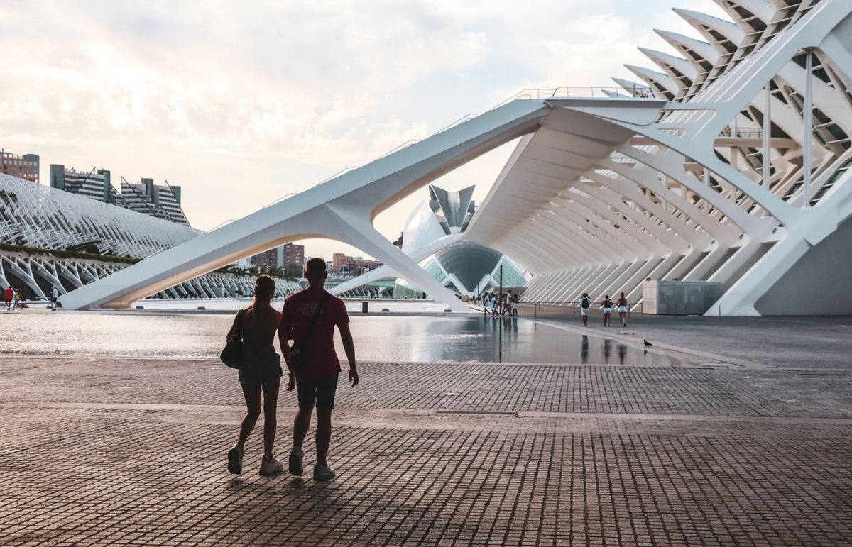 A couple walking at the City of Arts and Sciences in Valencia, Spain, showcasing stunning modern architecture.