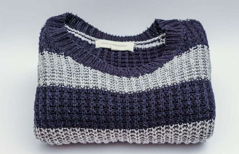 Warm knitted sweater with blue and white stripes, perfect for winter fashion.