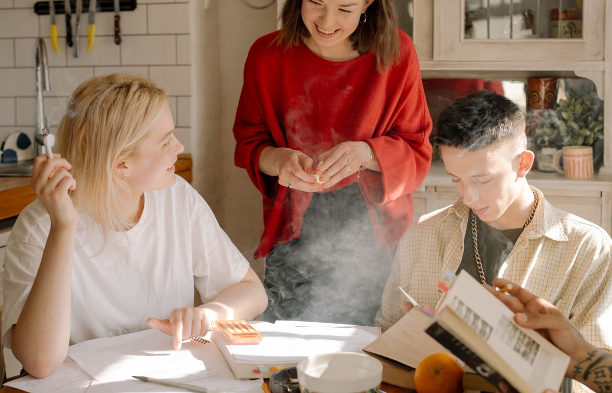 Young adults enjoying leisure time and conversation in a cozy kitchen environment.