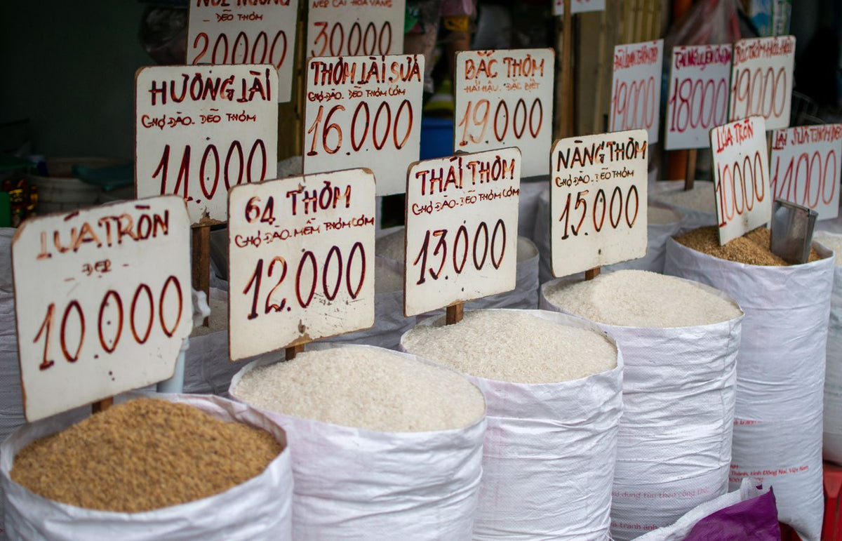 A display of various rice types for sale at a Ho Chi Minh City market stall.