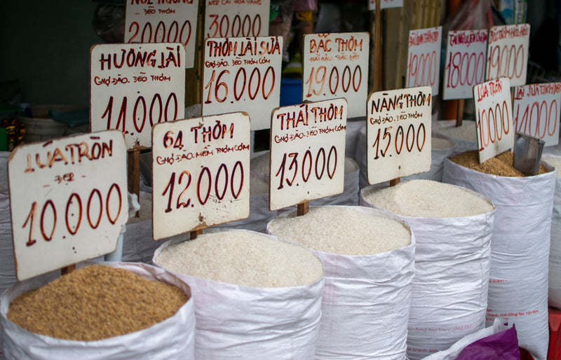 A display of various rice types for sale at a Ho Chi Minh City market stall.