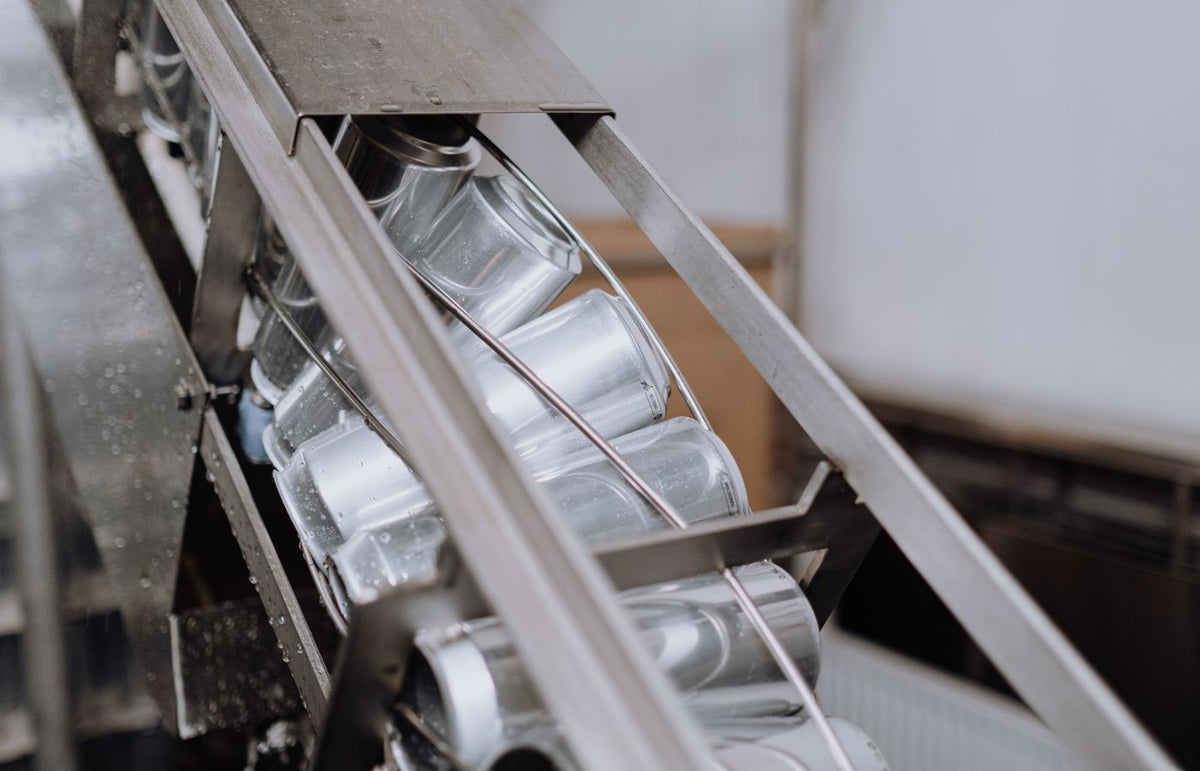 Close-up of automated canning equipment in a brewery showcasing production efficiency.
