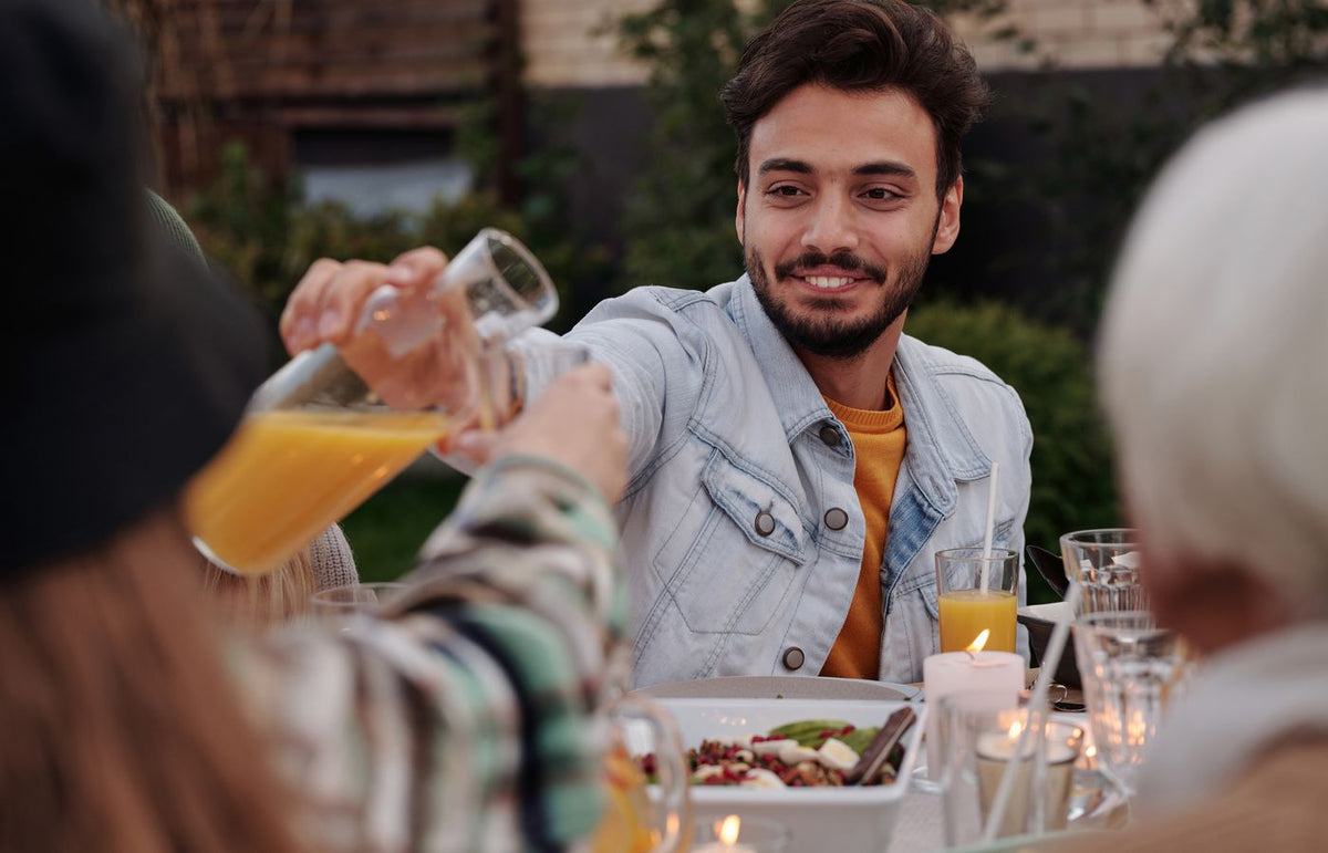 Joyful outdoor dinner gathering with friends and family enjoying meals and beverages.