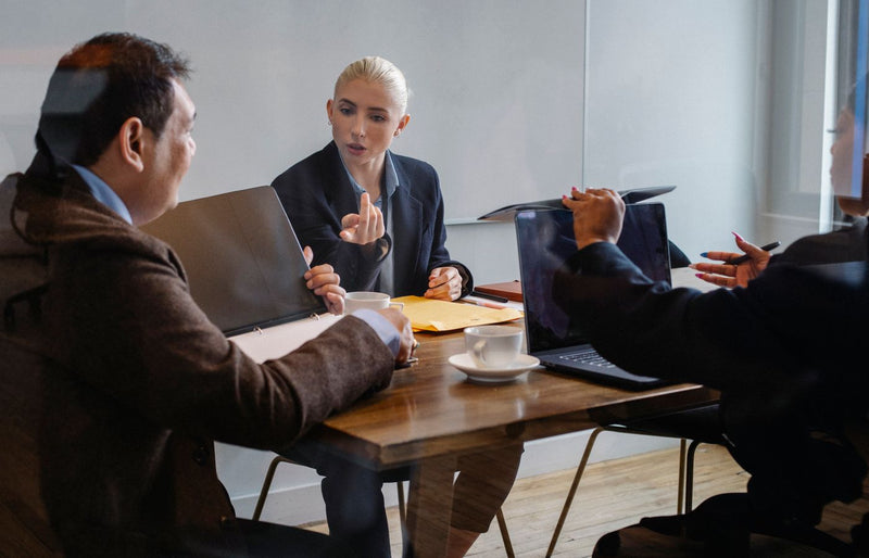 A diverse group of professionals collaborating during a business meeting in an office setting.
