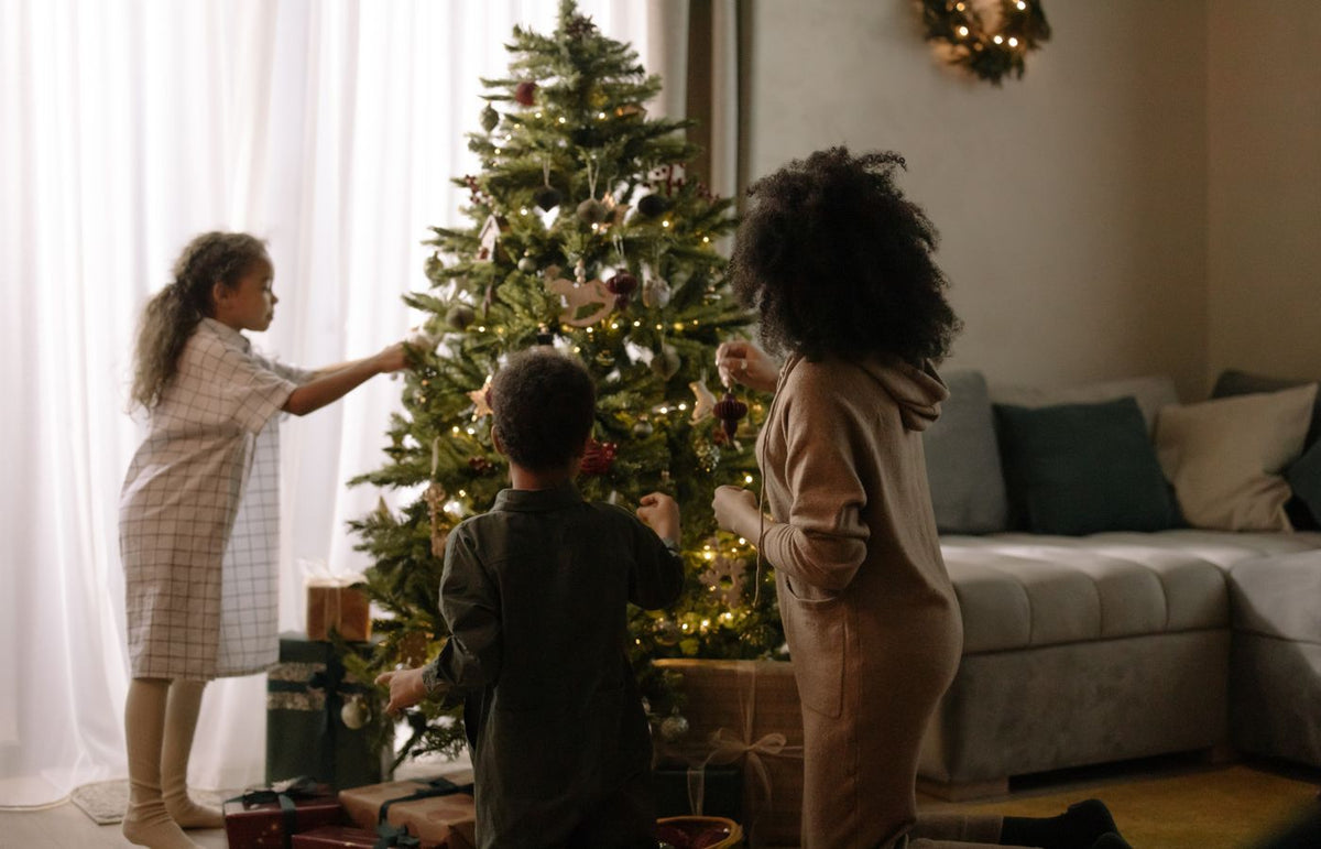 Cozy family moment decorating a Christmas tree indoors during the holiday season.