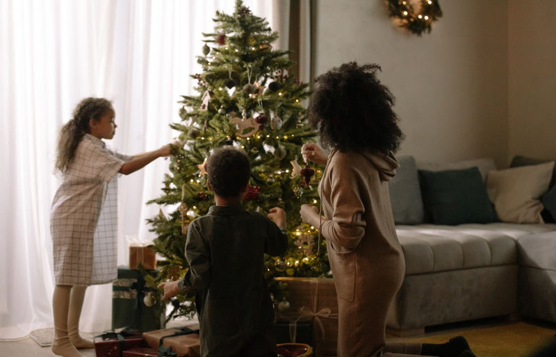 Cozy family moment decorating a Christmas tree indoors during the holiday season.