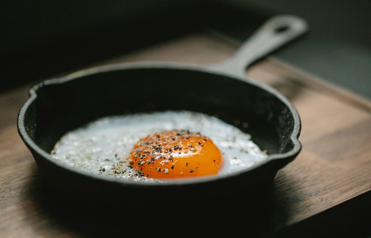Fried egg with pepper seasoning in cast iron skillet. Perfect breakfast shot.