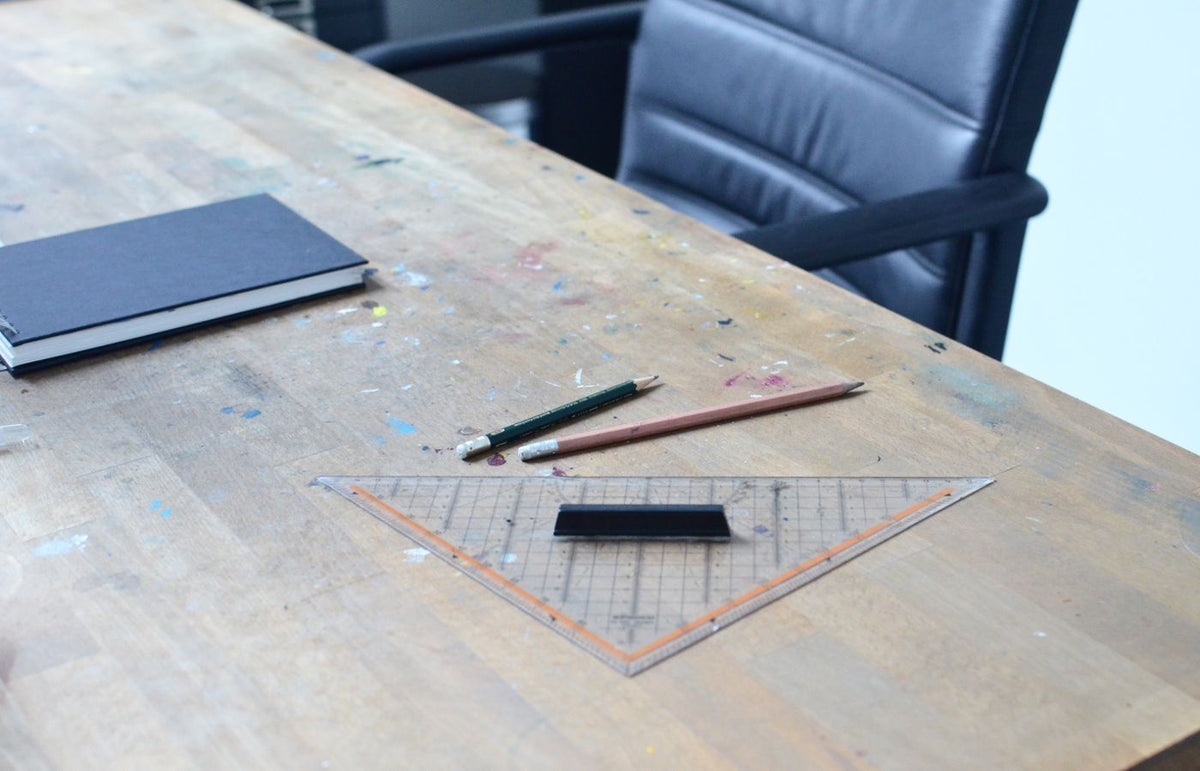 A cozy workspace featuring a notebook, pencils, and a ruler on a wooden table.