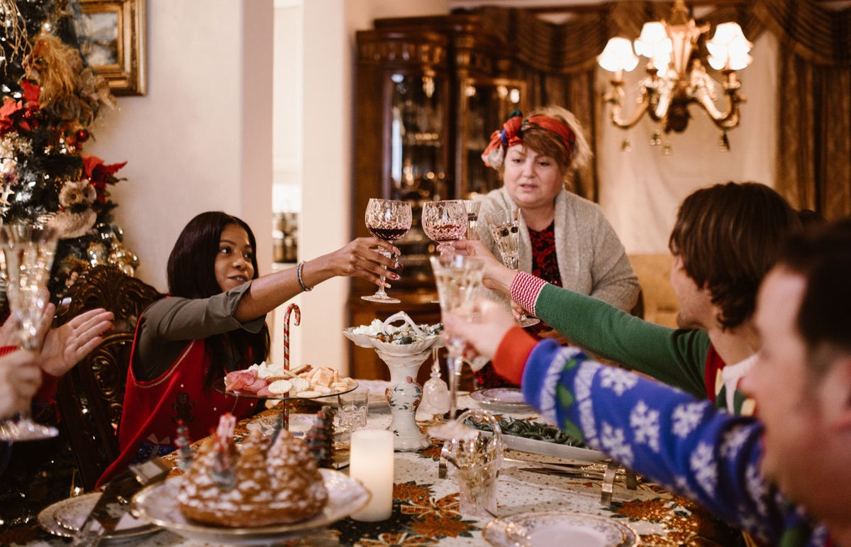 A joyful family gathering around a Christmas dinner table, toasting and celebrating together.