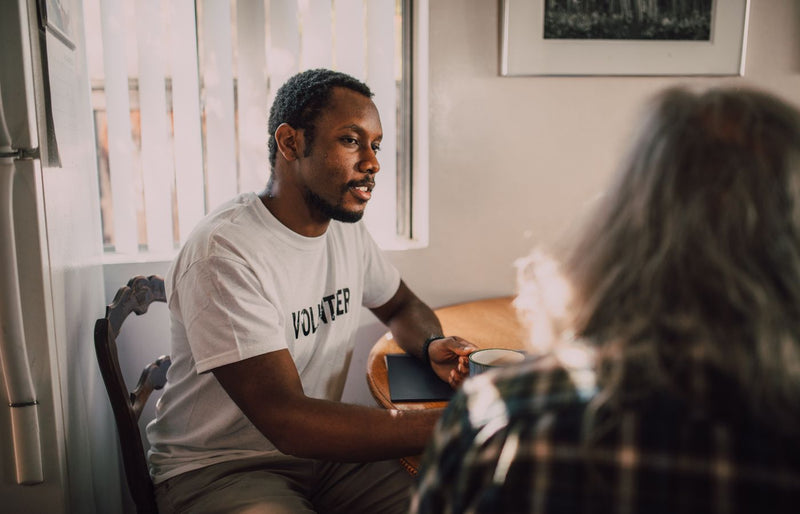 Two people having a thoughtful conversation in a bright and warm room.