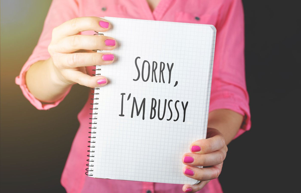 Woman holding a notebook with a handwritten message featuring a spelling error, showcasing humor and communication.