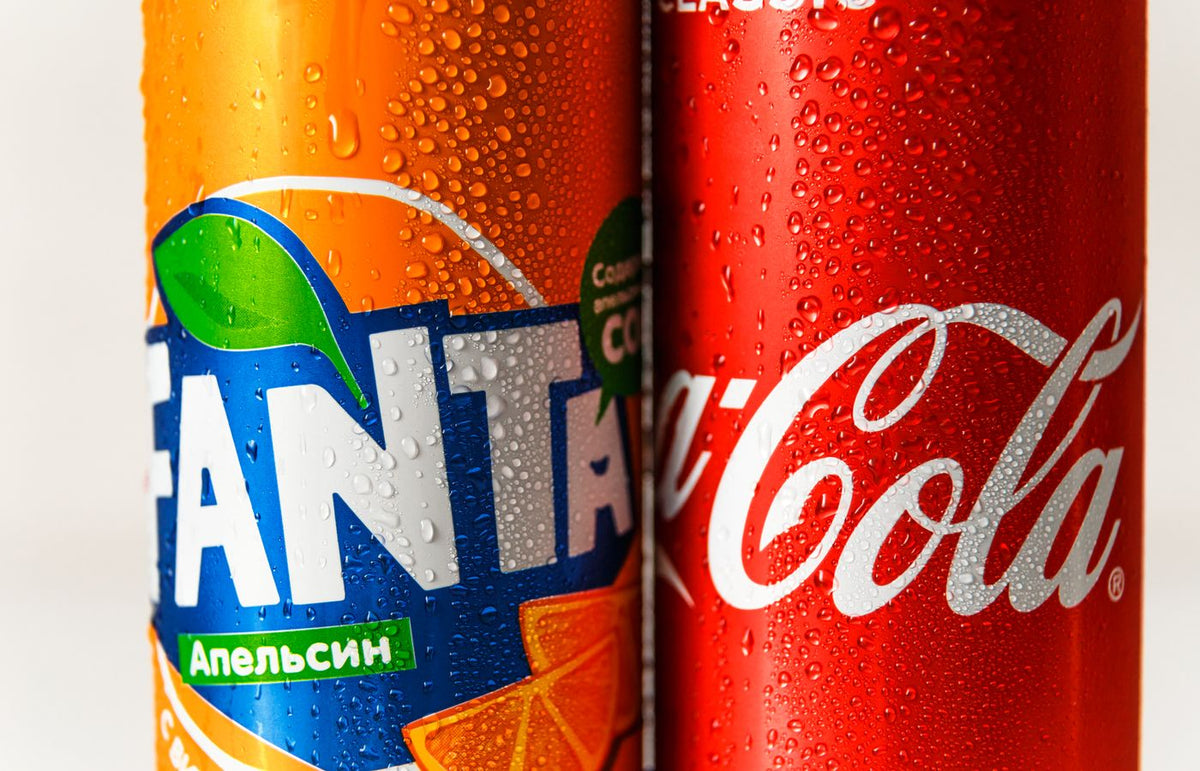 Refreshing close-up of wet soda cans, highlighting vibrant colors and textures.