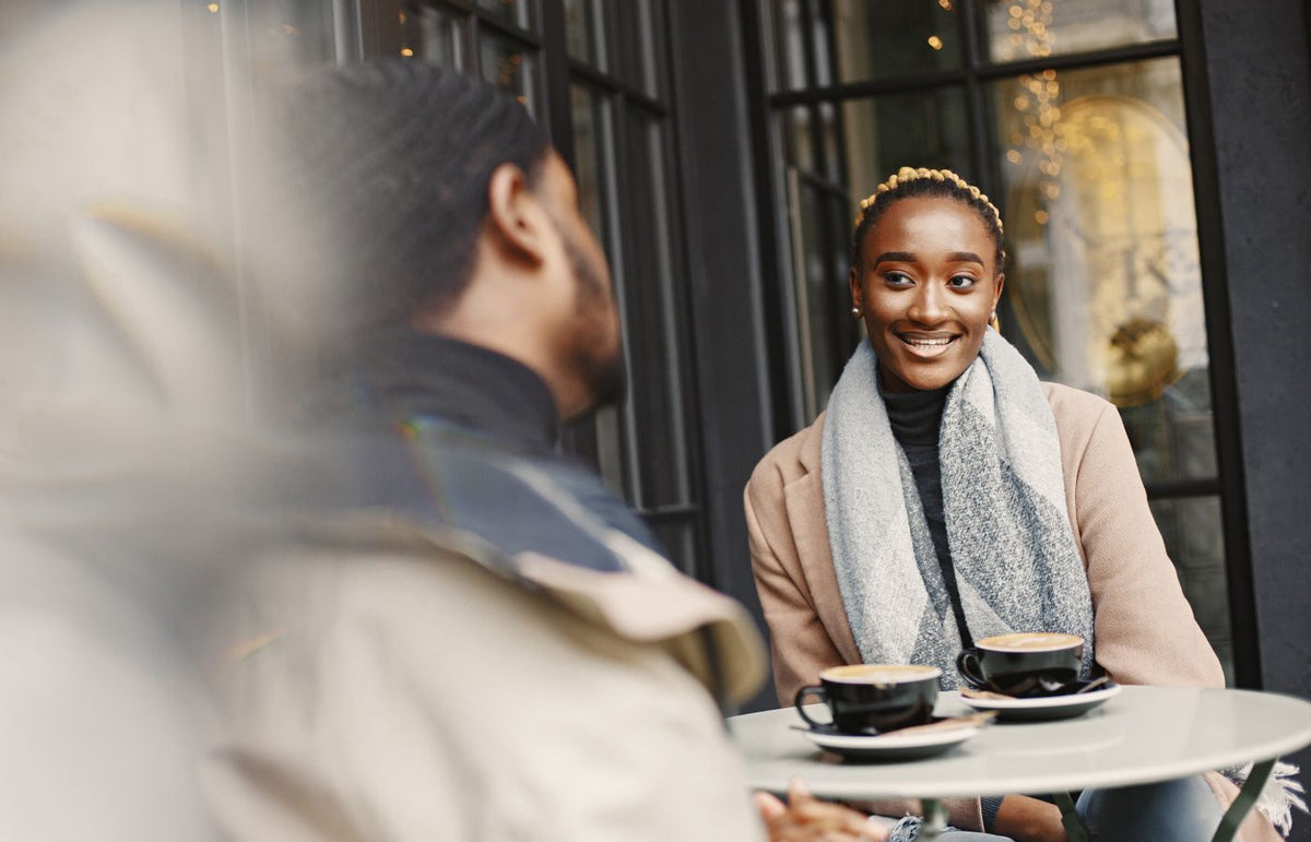 A joyful woman engaging in conversation at a stylish outdoor café setting.