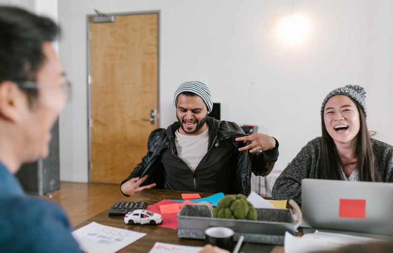 Diverse group in a creative meeting, sharing ideas and enjoying teamwork indoors.