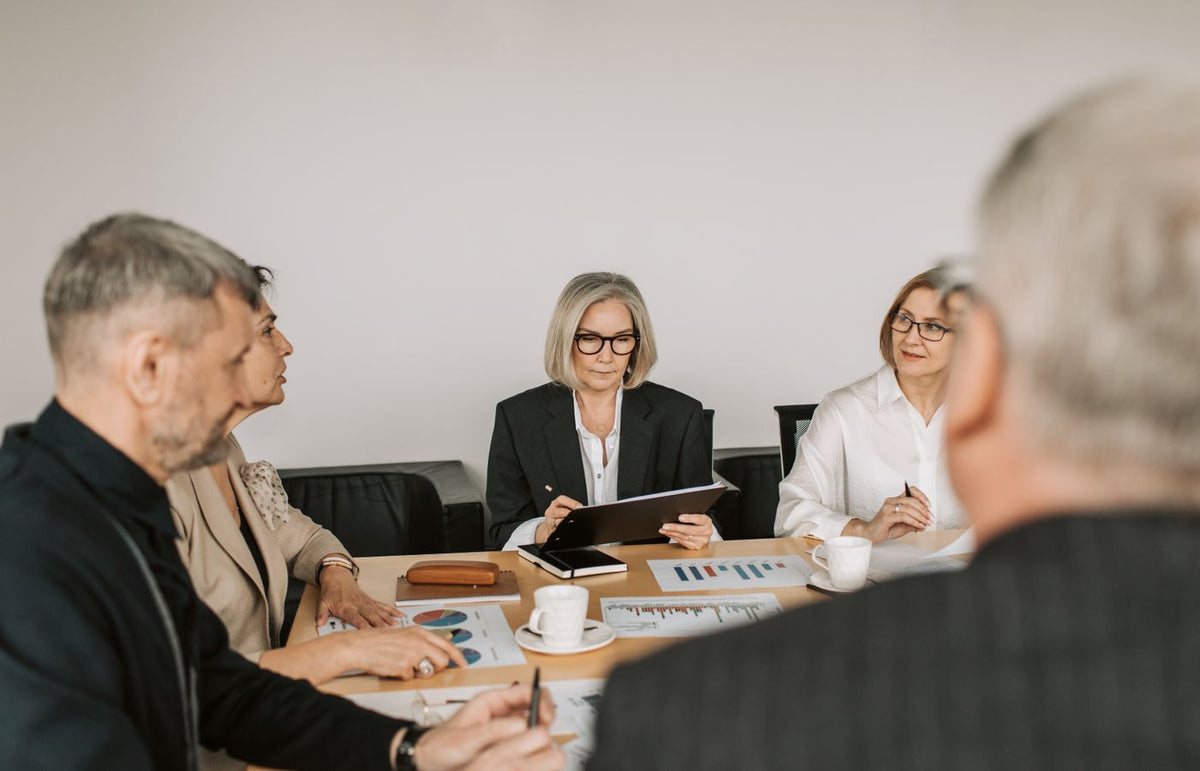 Senior professionals engaged in a collaborative business meeting in a modern office setting.