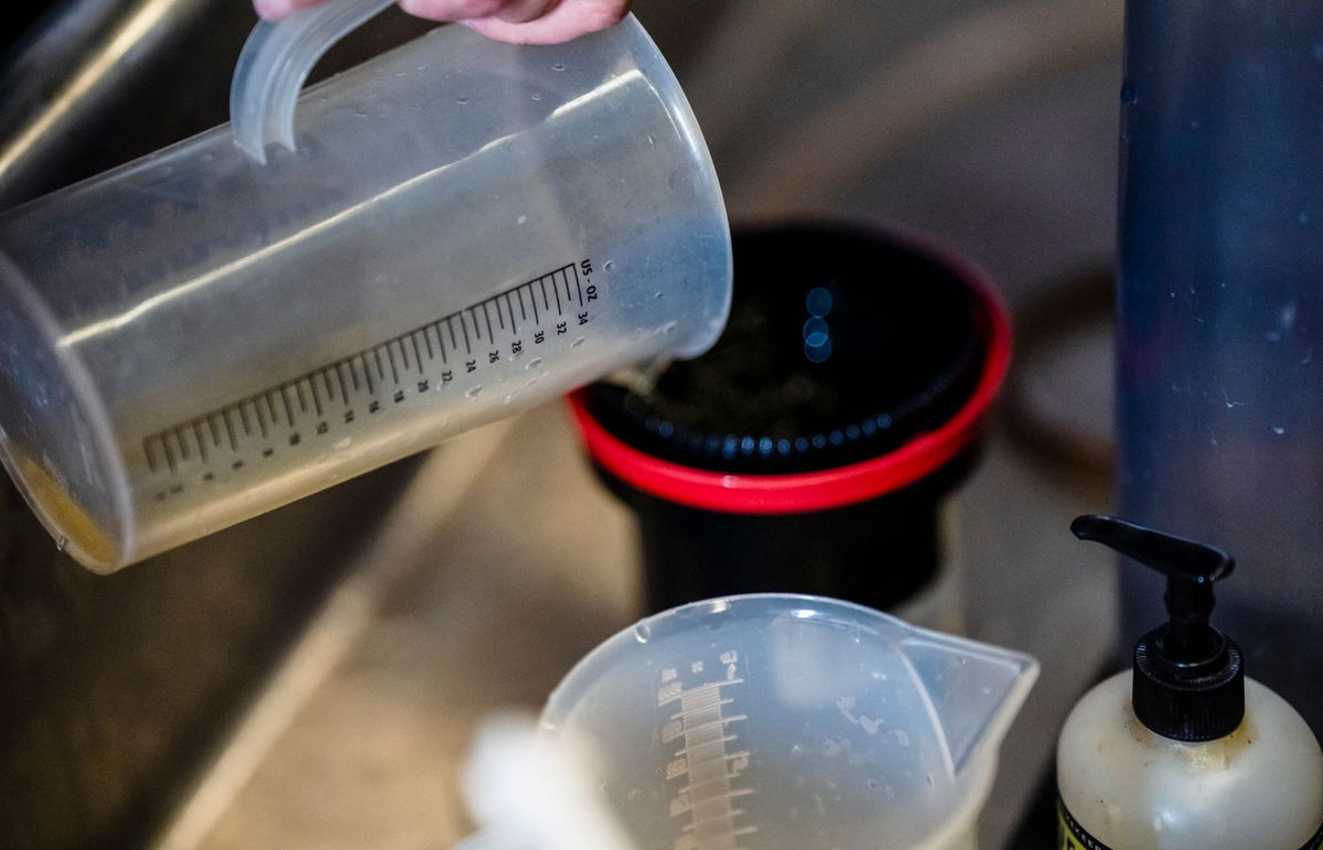 Close-up of a measuring cup being used to pour liquids in a kitchen environment.