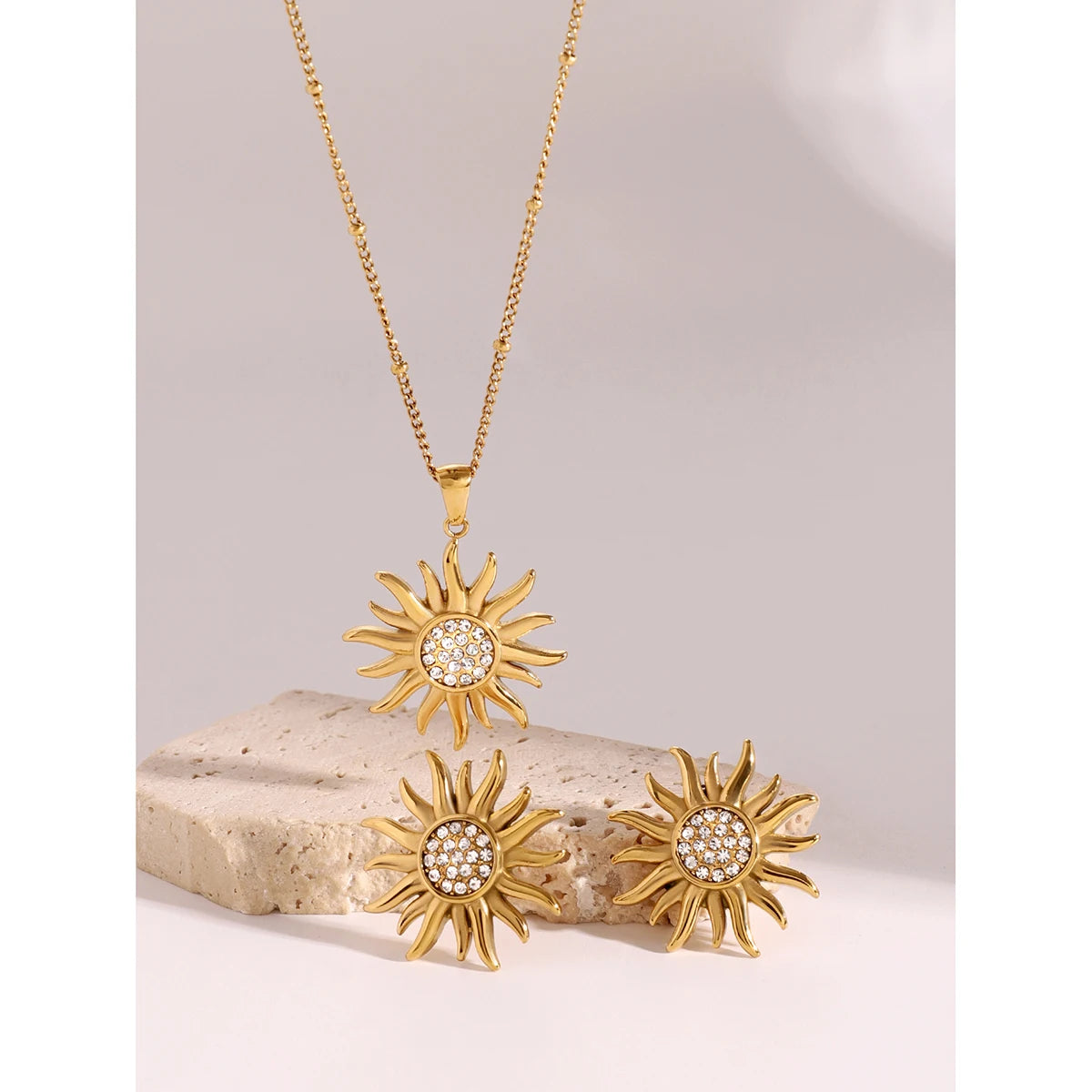 گردنبند و گوشواره ست زنانه بیژو با آویز شکل خورشید از جنس استیل ضد زنگ با روکش طلای 18 عیار و نگین رینستون، جواهرات ضد آب