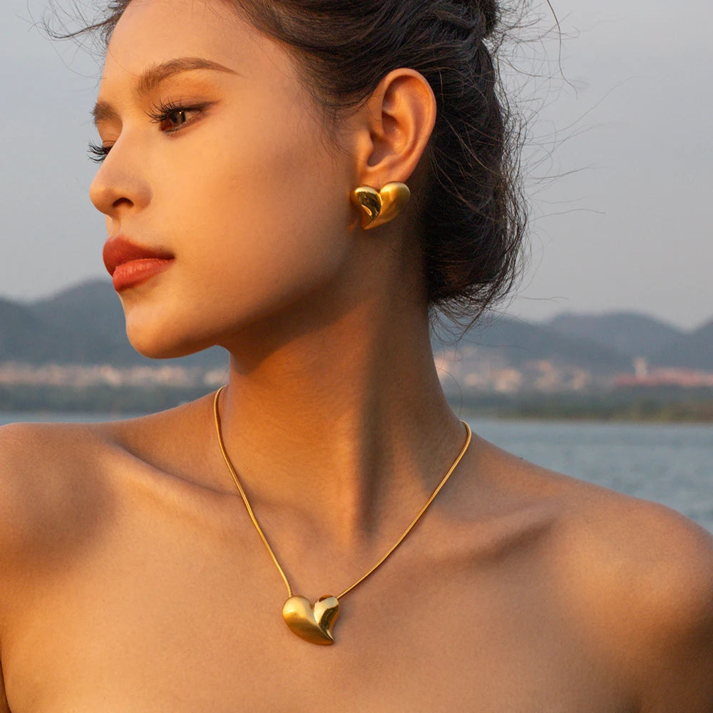 Halvfritliggende rustfrit stål 18K forgyldt kærlighedshjerte glatte børstede øreringe og halskæde Low Key Luksus Kvinder iført smykker